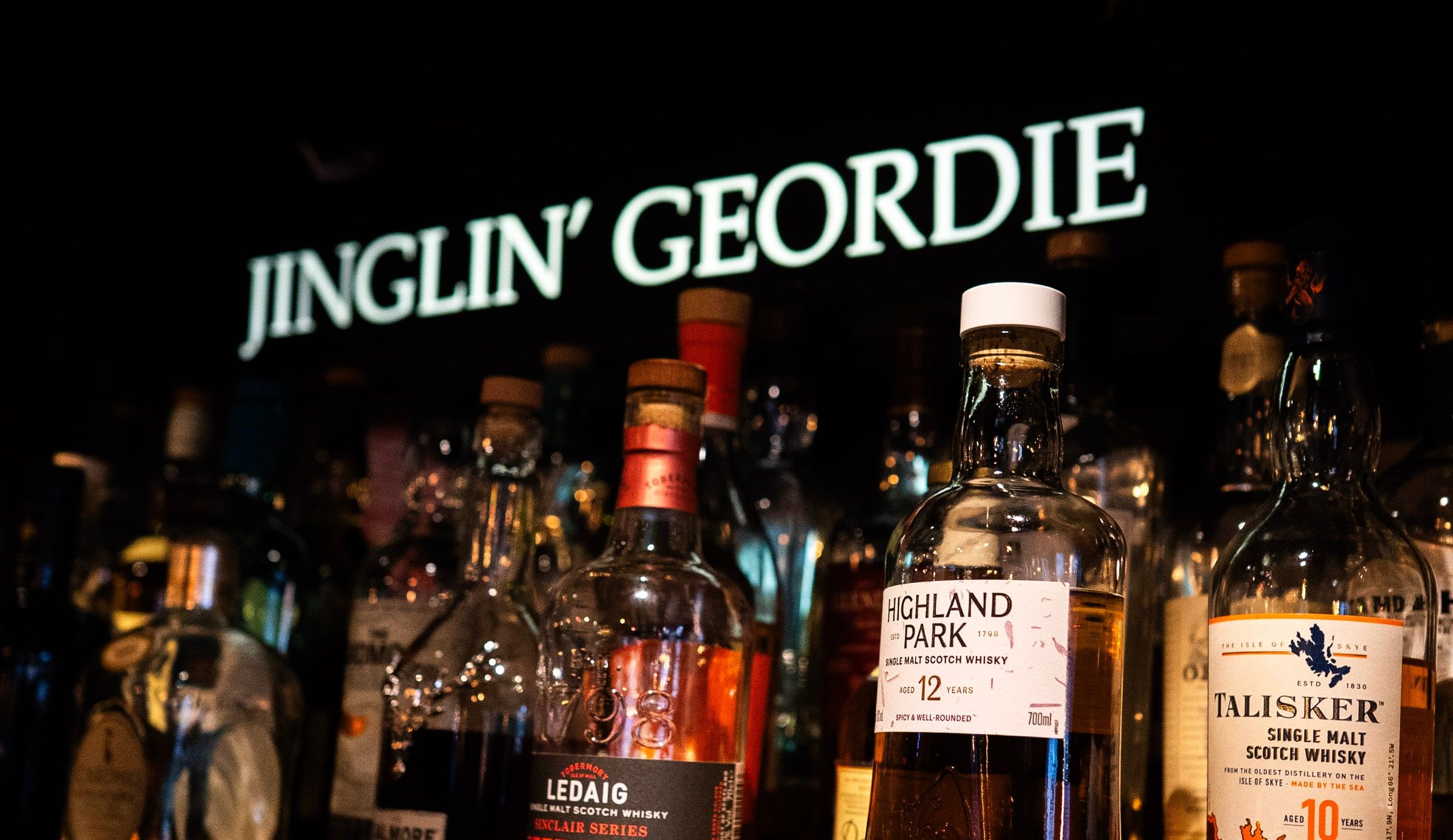 Bottles of malt whisky lined up under the Jinglin’ Geordie sign behind the bar